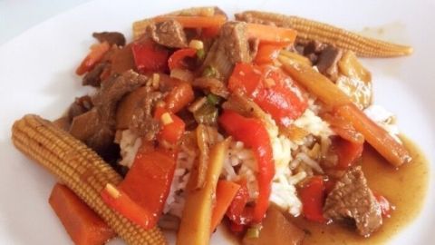Ein bunte Mischung aus zartem Fleisch, buntem Gemüse und Reis auf einem Teller, präsentiert als schnelles, köstliches Gericht.