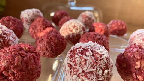 Himbeer-Pralinen liegen auf einem eleganten Glasbehälter und strahlen durch ihre fruchtige, gesunde Leckerei in verschiedenen Rottönen.
