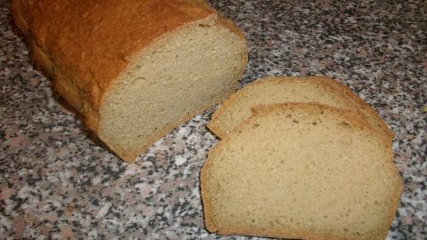 Eiweißbrot liegt auf einer Arbeitsfläche, zwei Scheiben sind abgeschnitten, bereit zum Genießen oder Servieren.