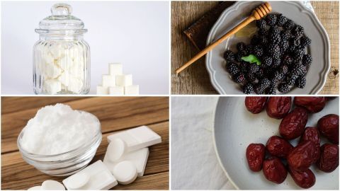 Ein Glass mit Zuckerwürfeln steht neben einer Schüssel mit Heidelbeeren und Honig, sowie einer kleinen Schale mit Kokoszucker und getrockneten Früchten.
