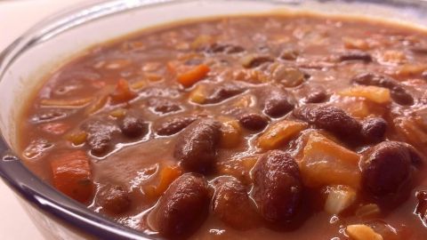 Eine Schüssel mit einer würzigen Mischung aus Hackfleischbällchen, Kidneybohnen und Gemüse steht auf einer Arbeitsfläche.