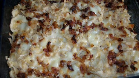 Ein schöner Auflauf von geschabten Käsespätzle ist goldbraun und knusprig, in einer rechteckigen Form serviert.