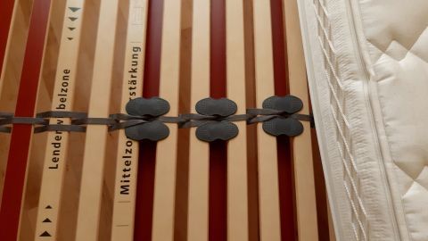 Ein Lattenrost mit fixierten Sperrgummis zeigt die Verbindung der Latten, die zur Stabilität des Matratzenunterbaus dient.