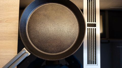 Eine schwarze Pfanne liegt auf einem Induktionsherd, bereit zum Kochen, ideal für Kochvorgänge ohne magnetischen Topf.