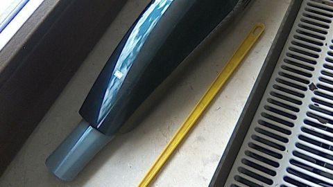 Ein Handstaubsauger liegt auf einem Fensterbrett und wird benutzt, um Mücken in der Wohnung zu bekämpfen.