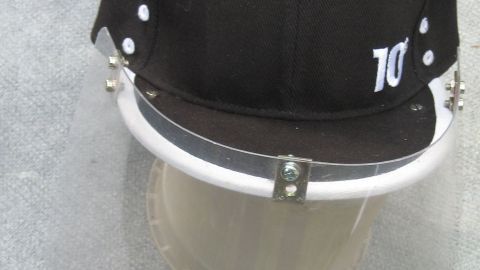 Eine schwarze Baseball-Cap mit einem Plexiglas-Visierschild schützt vor Tröpfchen und ist für Alltagssituationen geeignet.