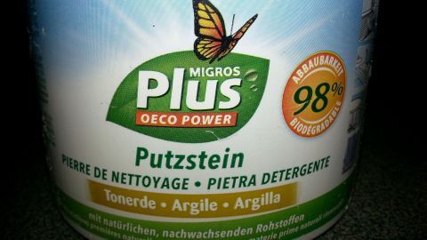 Ein Putzstein-Behälter steht auf einem dunklen Untergrund, umgeben von einer sauberen, aufgeräumten Umgebung.