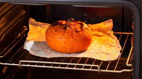Ein Kürbis befindet sich auf einem Backblech im Ofen, während er schonend gebacken wird, um Ansetzen zu vermeiden.