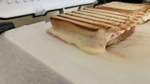 Ein Sandwich auf Backpapier geschmolzen, wird in einem Toaster gegrillt, um Zeit zu sparen und den Grill zu schonen.