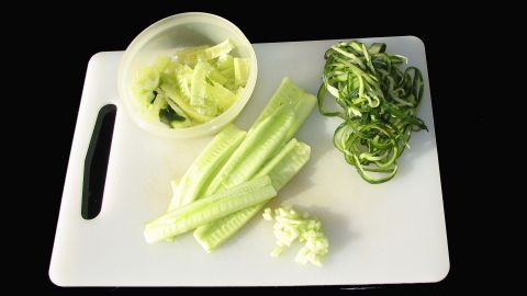 Salatgurkenstücke liegen auf einem Schneidebrett, während sie für verschiedene Gerichte vorbereitet werden.