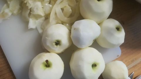 Ein Haufen geschälter Klaräpfel liegt auf einem Schneidebrett, bereit zur Verarbeitung für Apfelmus mit Ingwer.