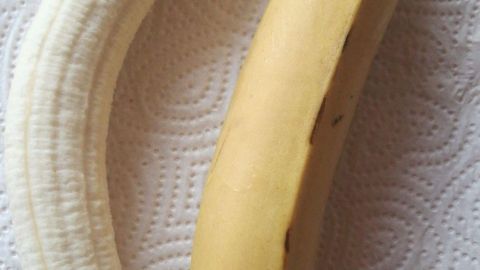 Eine gelbe Banane und eine weiße Banane liegen auf einem Küchentuch. Sie zeigen unterschiedliche Reifegrade.