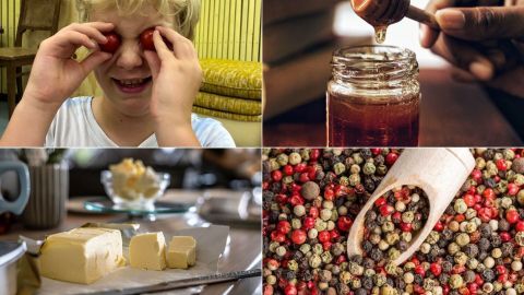 Ein fröhlicher Junge hält Tomaten vor seine Augen, während Honig in ein Glas tropft; im Hintergrund sind Käse und bunte Pfefferkörner zu sehen.