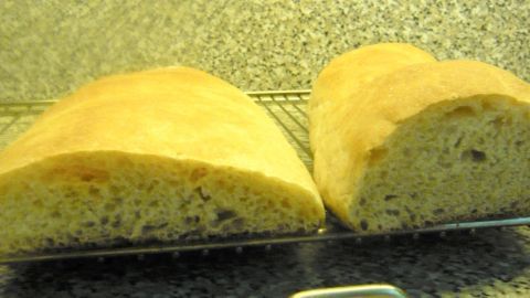 Zwei kürbisfarbene Brote liegen auf einem Gitter, frisch gebacken, mit einer weichen Kruste und luftiger Krume.
