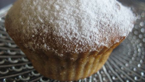 Die Muffins mit Puderzucker liegen auf einem dekorativen Teller, bereit zum Servieren und genießen.