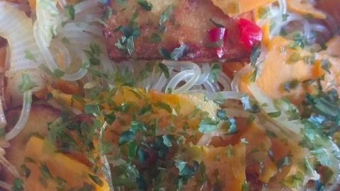 Eine bunten Reisnudel-Bowl zeigt zarte Glasnudeln, frisches Gemüse und Kräuter, die hier appetitlich angerichtet sind.