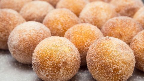 Goldene Quarkkrapfen liegen nebeneinander, bestäubt mit Zucker, frisch zubereitet und bereit zum Genießen.