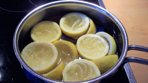 Im Topf schwimmen halbierte Zitronen, während sie erhitzt werden, um ein hausgemachtes Reinigungsmittel herzustellen.