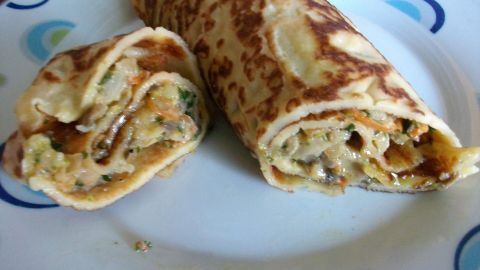 Zarte Pfannkuchen gefüllt mit Champignon-Gemüse stehen auf einem Teller und laden zum Genießen ein.