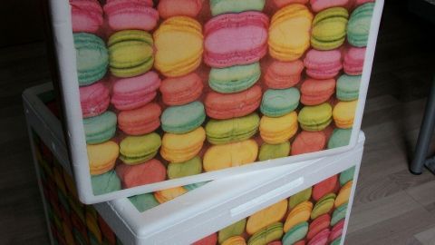 Zwei bunte Styroporboxen mit einem Muster aus Macarons stehen im Raum und sind bereit zum Recycling.