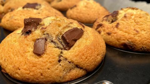 Goldene Eierlikör-Muffins mit Schokostückchen liegen warm in einer Muffinform und laden zum Genießen ein.
