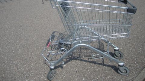 Ein Einkaufswagen steht stabil auf einem Parkplatz und wartet darauf, benutzt zu werden, ohne sich selbstständig zu machen.