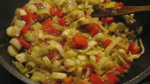 Bunte Paprika und Chicorée werden in einer Pfanne leicht angebraten, um ein schmackhaftes Gemüsegericht zuzubereiten.