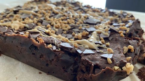 Köstliche Espresso-Brownies mit Kidneybohnen liegen auf Backpapier, dekoriert mit Schokoladensplittern und knusprigen Häufchen.