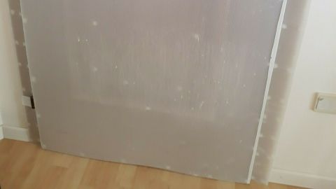 Eine Holztür ist mit einem transparenten Kratzschutz versehen, um Beschädigungen durch Katzen zu vermeiden.