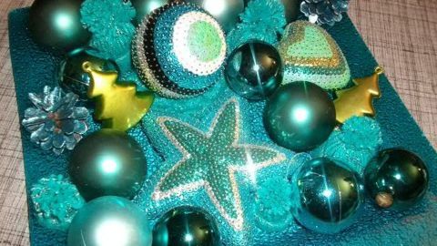Farbenfrohe Pailletten und Dekokugeln liegen auf einem glitzernden Hintergrund, dekorierend für Geschenke und Festlichkeiten.