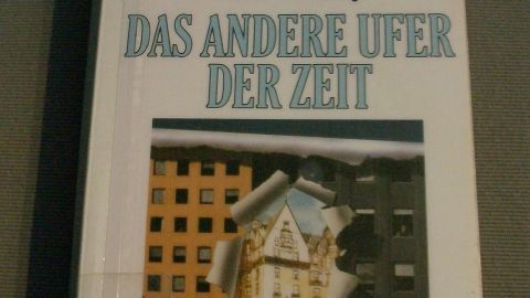 Ein Buchcover zeigt ein Gebäude, das durch ein gerissenes Papier sichtbar wird, umgeben von modernen Hochhäusern.
