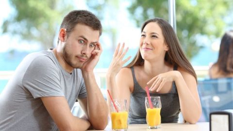 Eine Frau spricht lebhaft mit einem Mann in einem Restaurant, während sie zwei Fruchtsäfte vor sich haben.