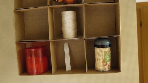 Ein geöffneter Schrank zeigt eine praktische Stauraum-Lösung mit Fächern, die mit verschiedenen kleinen Gegenständen gefüllt sind.
