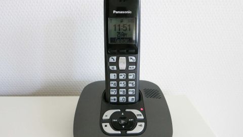 Ein schnurloses Telefon steht auf einer Basisstation und zeigt die Uhrzeit an, bereit für kostenloses Telefonieren.