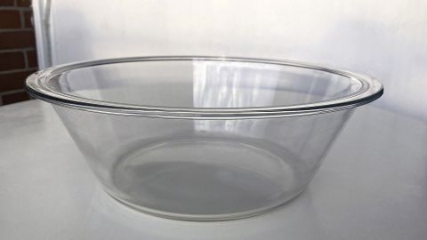 Eine durchsichtige Schüssel steht auf einem Tisch und könnte als Teil eines Upcycling-Projekts verwendet werden.