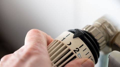 Ein Heizkörperthermostat wird angepasst, um sparsam zu heizen und Schimmelbildung an den Wänden zu vermeiden.