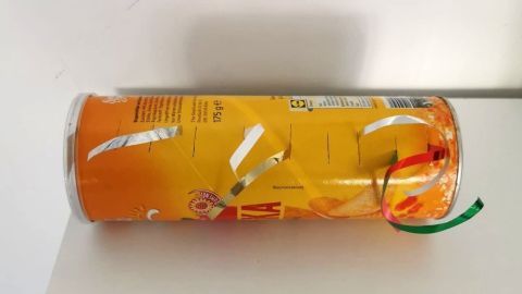 Ein runder Behälter mit Geschenkband liegt auf einem Tisch, bereit zur Aufbewahrung von Geschenkband in einem hellen Raum.