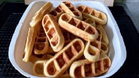 Waffelsticks liegen gestapelt in einer weißen Schüssel und bieten eine knusprige, gebräunte Oberfläche.