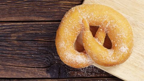 Eine goldene Martinsbrezel liegt auf einem Holzbrett, umgeben von einem rustikalen, hölzernen Hintergrund.