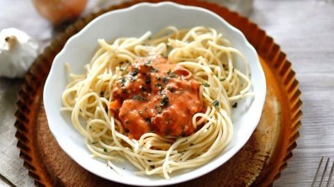 Ein Teller Spaghetti Bolognese präsentiert die Pastagerichte mit einer herzhaften Sauce, auf einem rustikalen Tisch gedeckt.