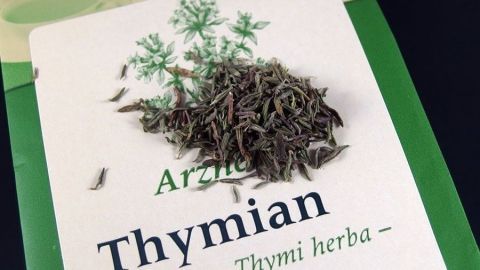 Getrockneter Thymian liegt auf einer Verpackung, die die Verwendung von Thymian für teeliefernde Anwendungen zeigt.