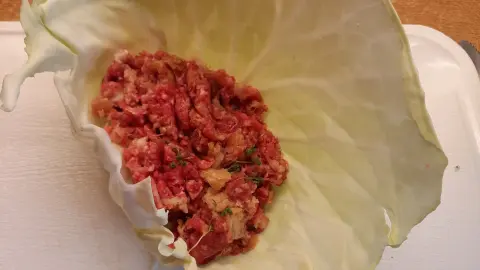 In je ein Blatt des flachen Krautkopfs kommt nun die fertige F&uuml;llung. Dann wird aufgerollt.