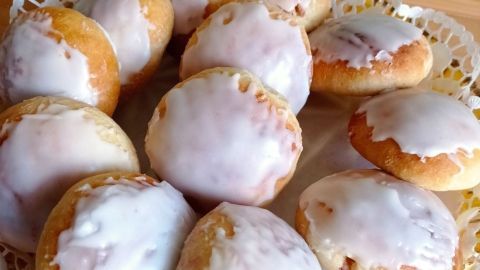 Die frisch gebackenen Berliner mit Zuckerglasur sind auf einem dekorativen Teller angerichtet und verlockend.
