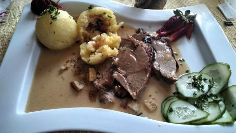 Zarte Putenoberkeule liegt in einer cremigen Rahmsoße, begleitet von Kartoffelknödeln und frischem Gemüse.