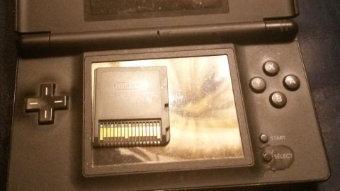 Ein Nintendo DS liegt geöffnet auf einem Tisch, zeigt einen nicht erkannten Spielmodus und einen eingelegten Spielchip.