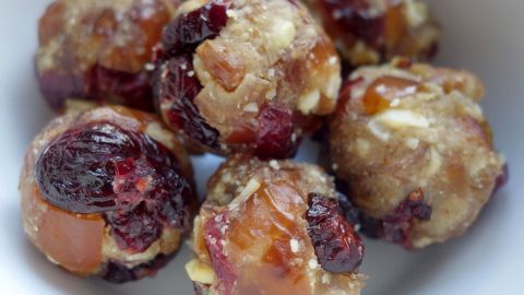 Kleine Energiebälle mit Datteln und Cranberries liegen in einer Schüssel, bereit zum Genießen.