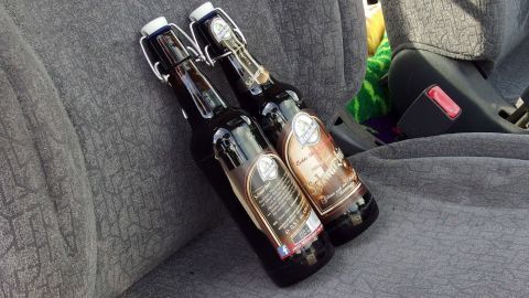 Zwei Bierflaschen stehen auf dem Autositz, bereit zum Konsum während eines geselligen Abends beim Beschleunigungssaufen.