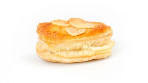 Zarte Puddingteilchen aus Blätterteig liegen appetitlich auf einem weißen Untergrund, verziert mit mandelähnlichen Scheiben.