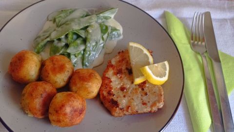 Schweineschnitzel mit Kartoffelbällchen und Zuckerschoten