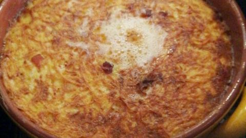 Eine runde, gebräunte Eifeler Döppekuchen ist in der Heißluftfritteuse sichtbar und sprudelt leicht vor sich hin.